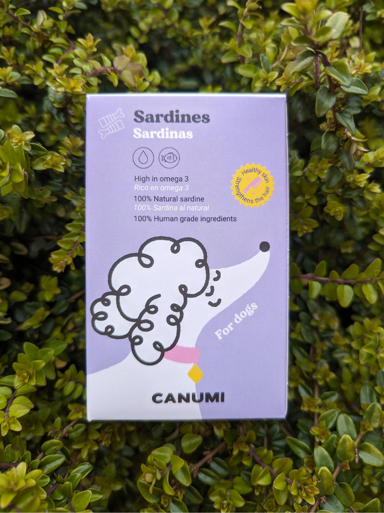 A package of Canumi Atlantic Sardines placed against a leafy background, highlighting the product as pet food.