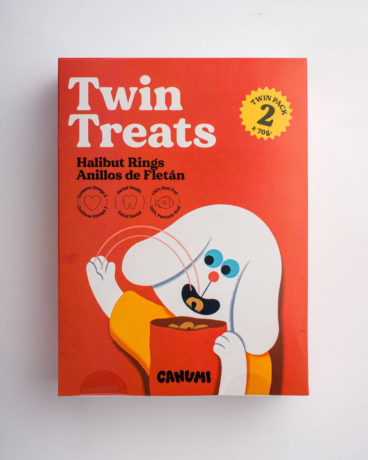 A red box of CANUMI Twin Treats Halibut Rings, featuring a cartoon white dog eating halibut rings, on a clean white background.