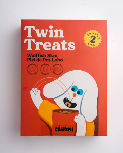 A twin pack box of Canumi Twin Treats Wolffish Skin, featuring a bright red background with a cartoon white dog character holding a bowl of treats.