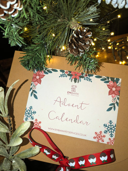 Advent calendar with floral design and red ribbon, placed under a Christmas tree.